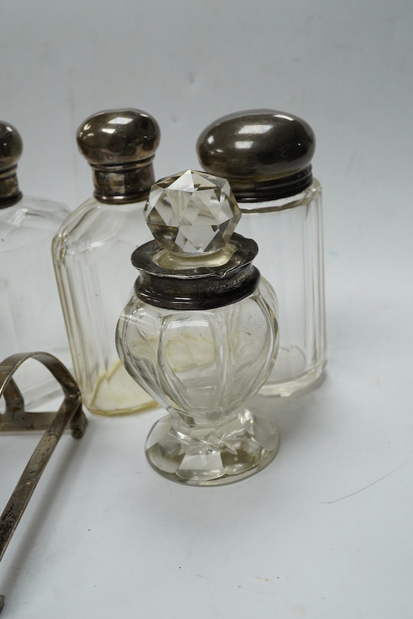 An Art Deco silver five bar toast rack by Charles S. Green & Co Ltd, Birmingham, 1935, 9cm, a silver napkin ring and six assorted silver topped glass toilet bottles. Condition - poor to fair